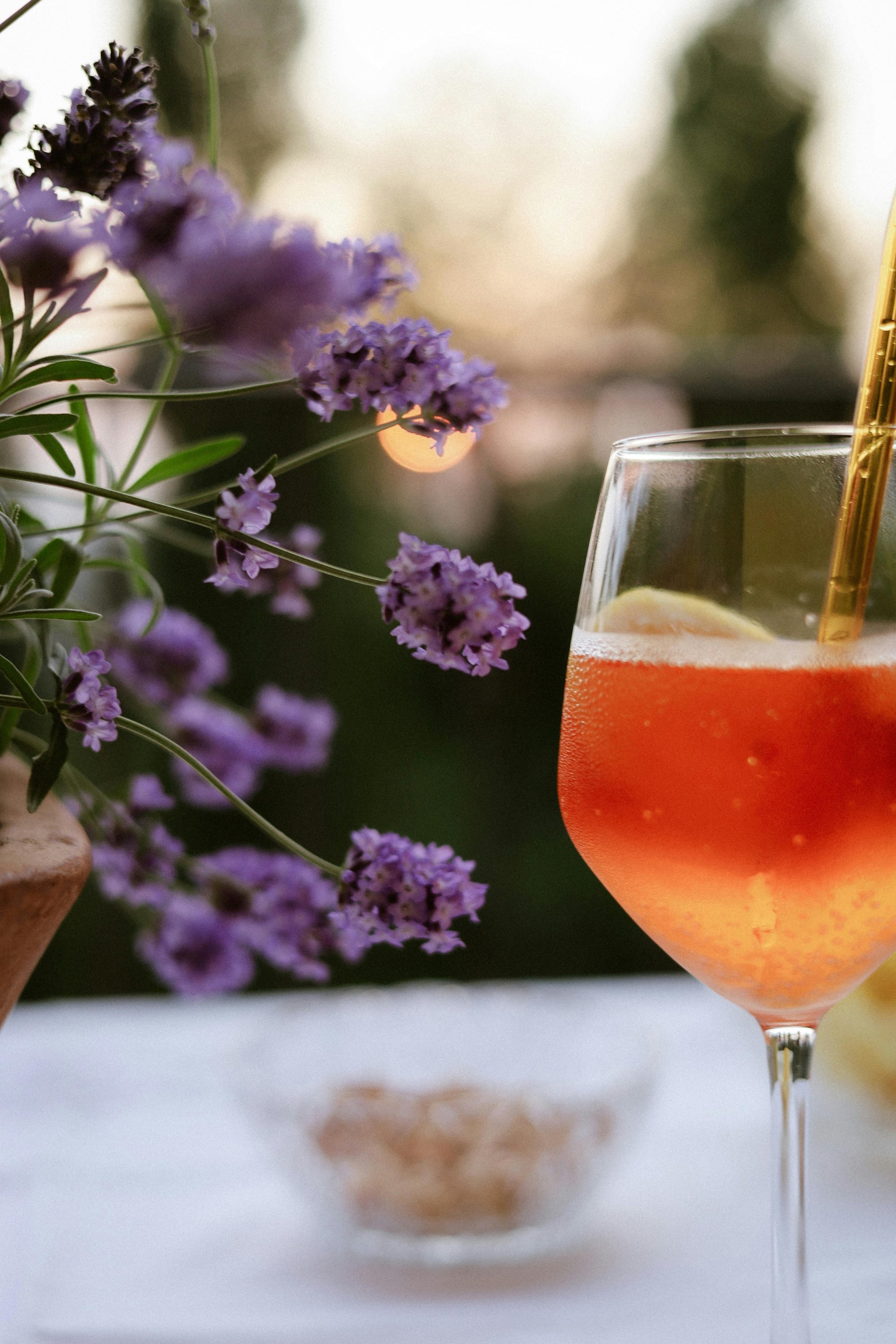 Gin cocktail on a white table at a Farnham gin bar hire event, with floral arrangement in the background