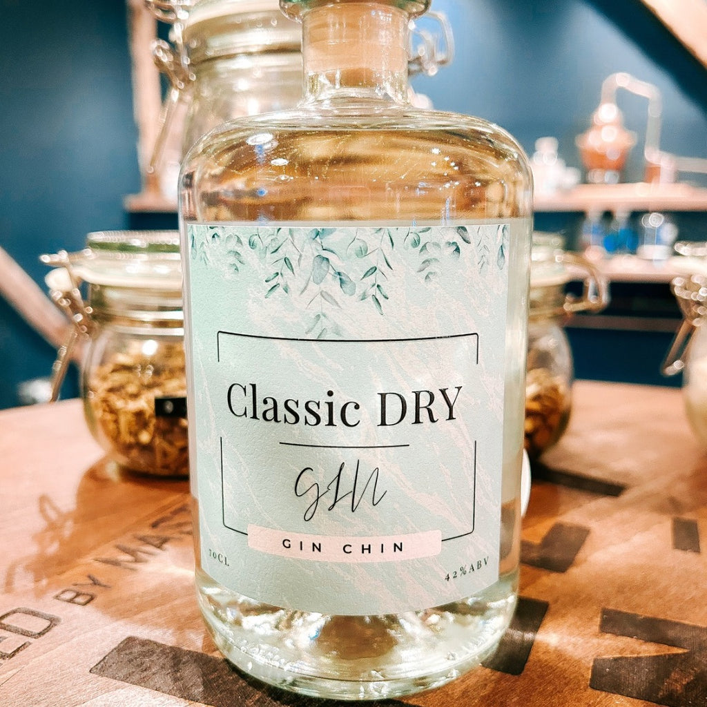 Bottle of Classic Dry Gin Chin small batch gin on a wooden surface with a blurred background