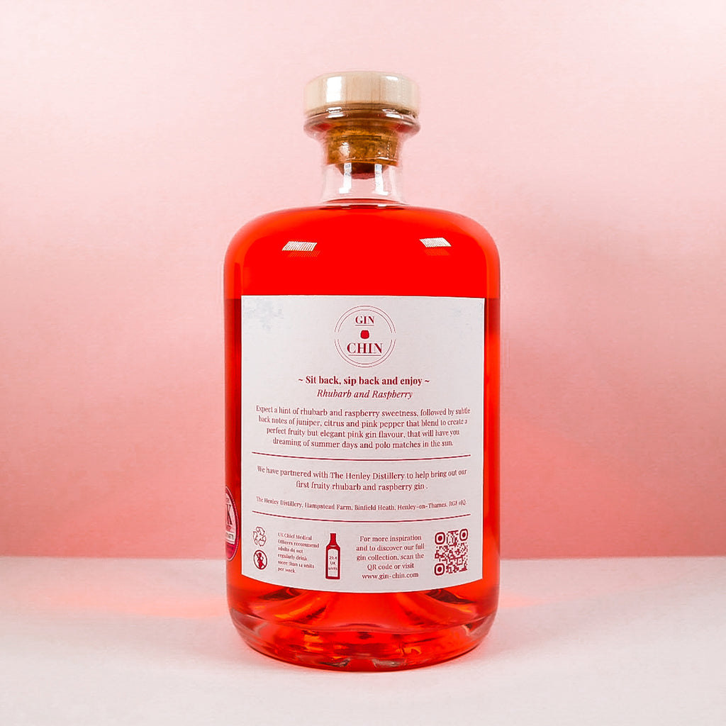 Bottle of Gin Chin Rhubarb and Raspberry artisan gin with a white label on a pink background