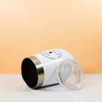 White insulated travel tumbler with a clear lid on a light peach background