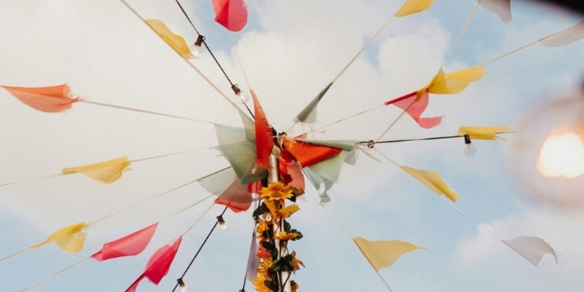 Decorative flags with flowers against a blue sky